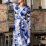 Kobieta w eleganckiej sukience z abstrakcyjnym wzorem, artystyczne studio z sztalugami