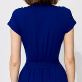 Niebieska sukienka z krótkim rękawem i pasem, widok od tyłu, precyzyjne krawiectwo, wygodna stylizacja