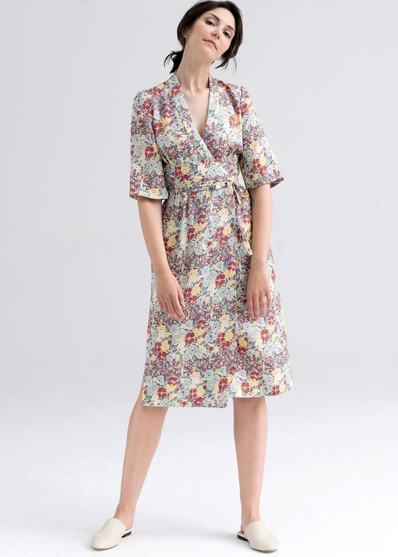 Kobieta w kwiecistej sukience midi z wiązanym pasem, idealna na codzienne stylizacje i self-care fashion