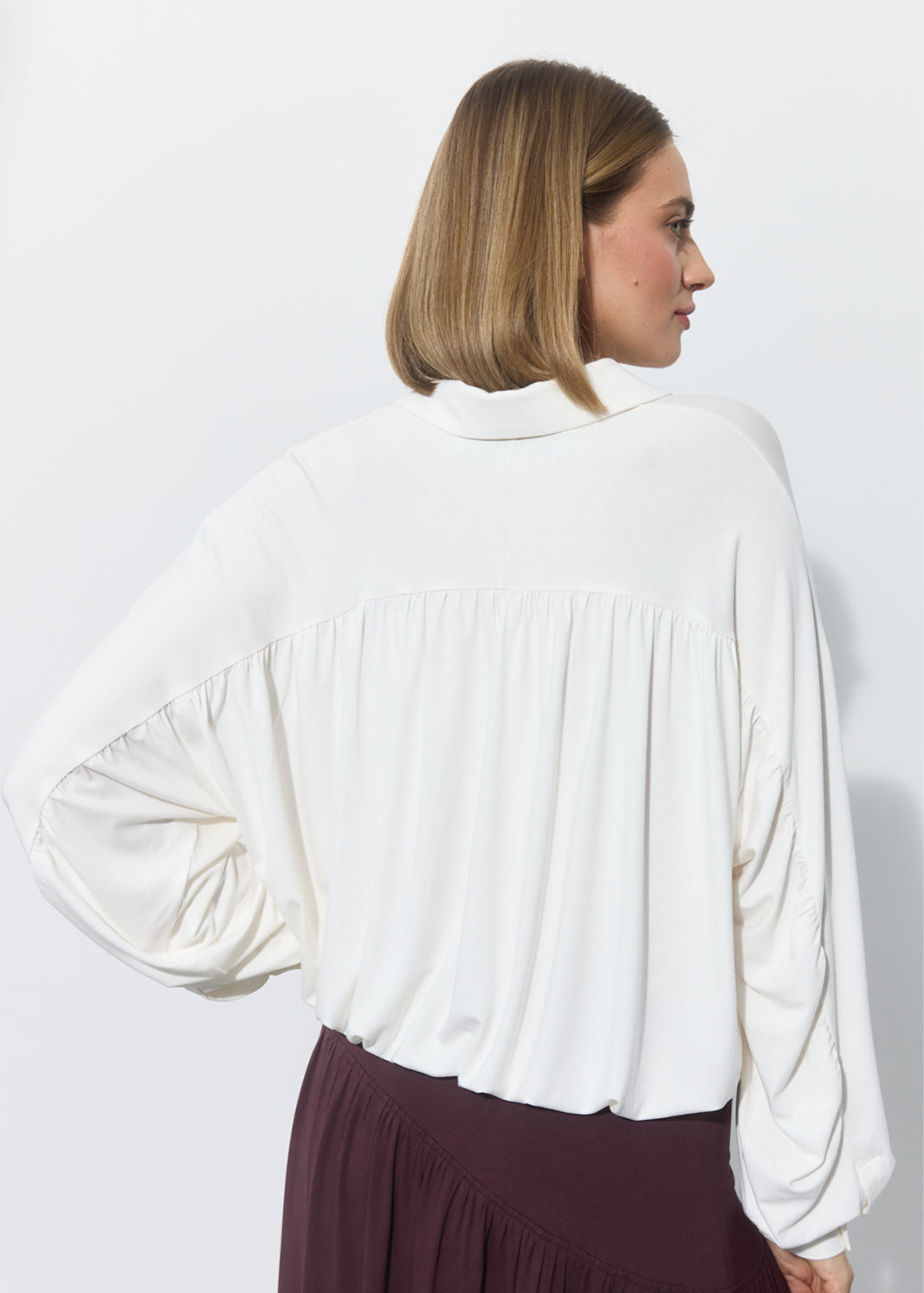 Biała bluzka z bufiastymi rękawami i marszczonym tyłem, stylowa i wygodna