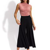 Różowa bluzka z marszczonymi detalemi i czarne spodnie typu culottes – elegancka stylizacja na co dzień