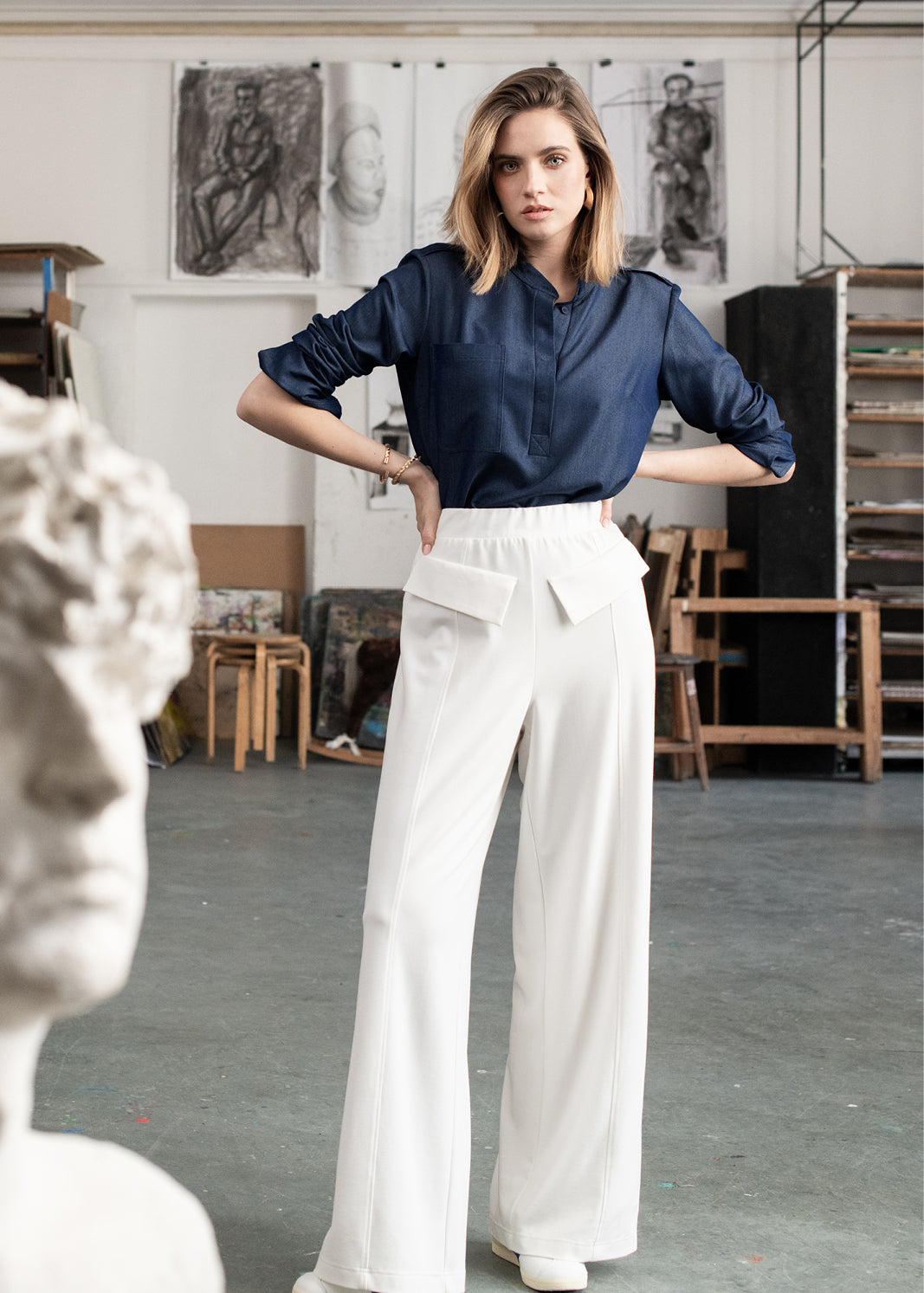 Kobieta w białych spodniach wide leg i granatowej koszuli, stylowy strój na co dzień, moda polska