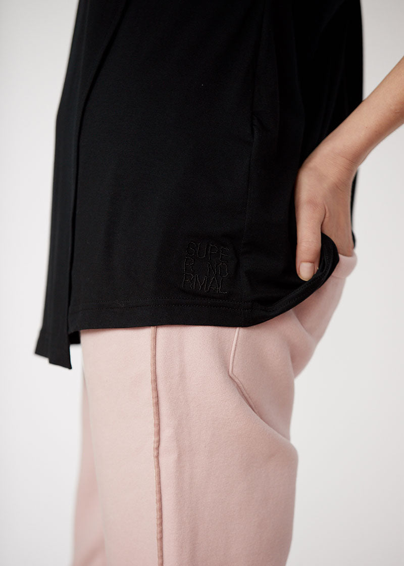 Czarna bluza z napisem 'SUPER NORMAL' i różowe spodnie – wygodny styl codziennego self-care fashion