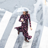 Kobieta w kwiecistej sukience z parasolką na mokrym przejściu dla pieszych, moda polska, self-care fashion
