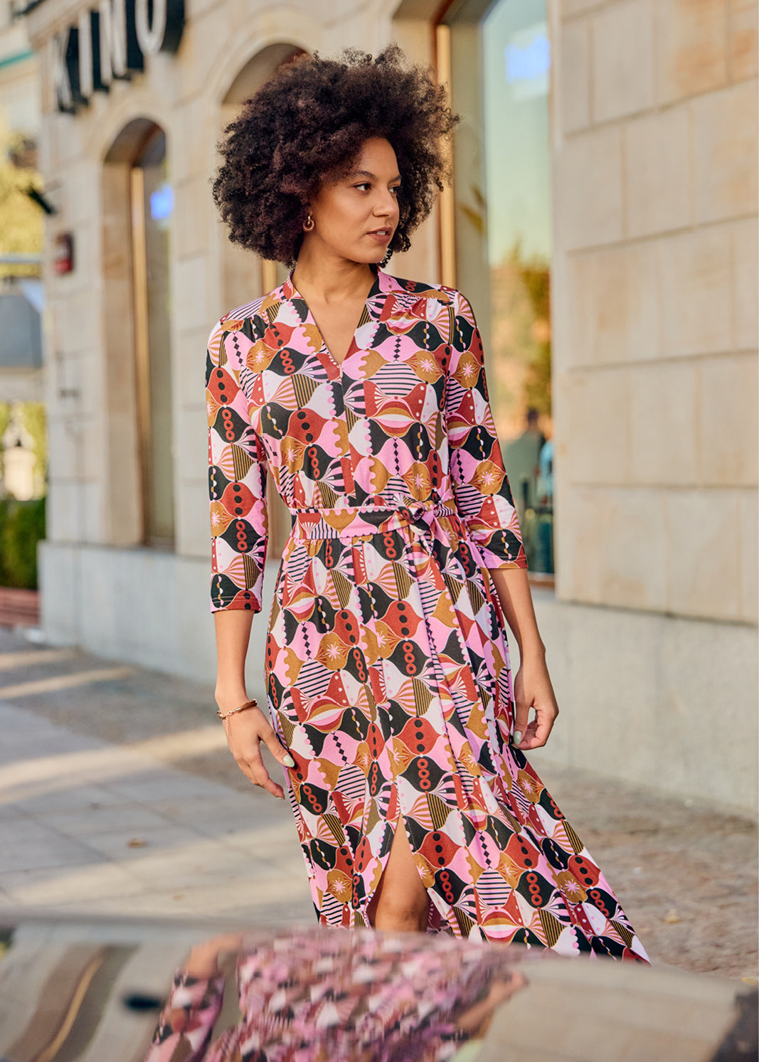 Kobieta w kolorowej, geometrycznej sukience z pasem, stylowa moda uliczna, wygodna i elegancka