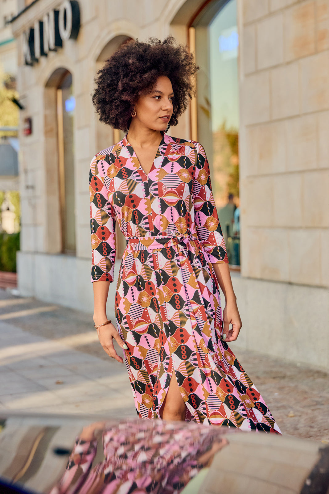 Kobieta w kolorowej, geometrycznej sukience z pasem, stylowa moda uliczna, wygodna i elegancka