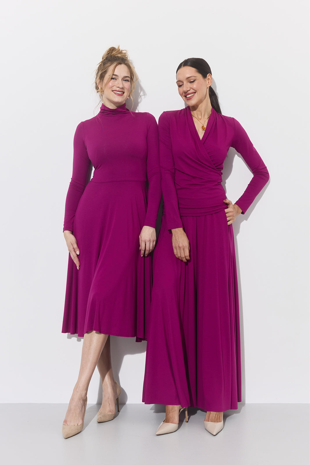 Dwie kobiety w fioletowych sukienkach z długim rękawem, eleganckie i wygodne, idealne na każdą okazję.