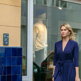 Kobieta w eleganckiej granatowej sukience z wiązaniem, stylowa moda uliczna z kulturą i wygodą