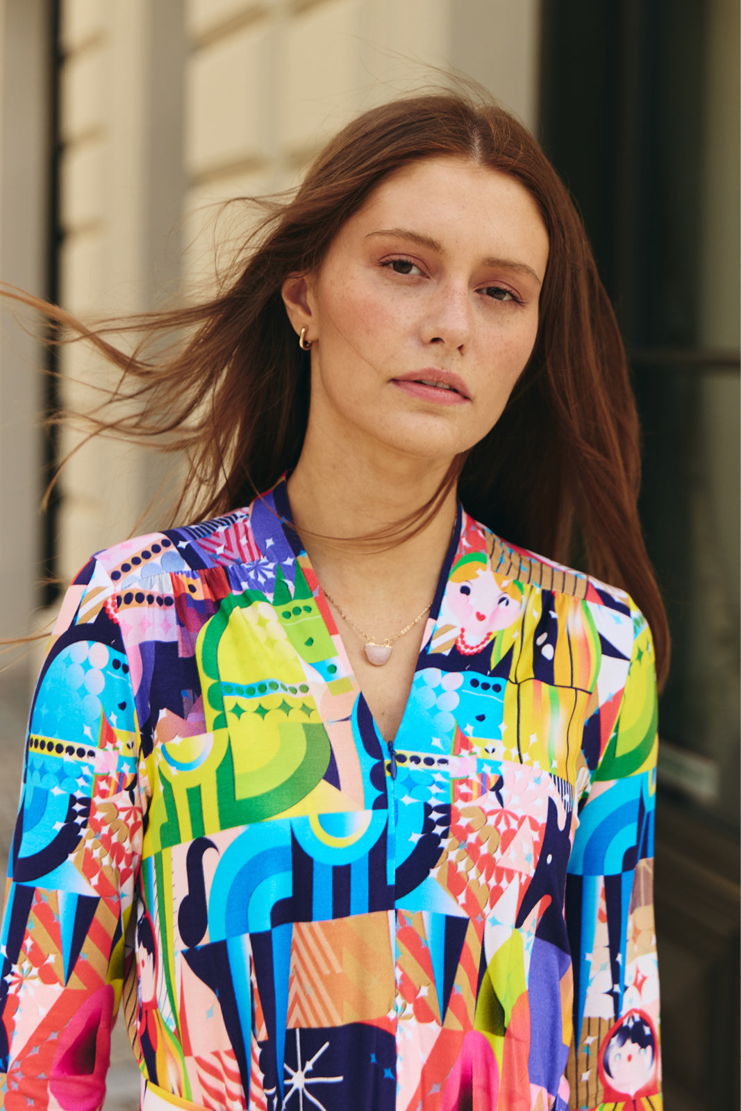 Kobieta w kolorowej, artystycznej sukience z geometrycznym wzorem, idealna na codzienne stylizacje i self-care fashion